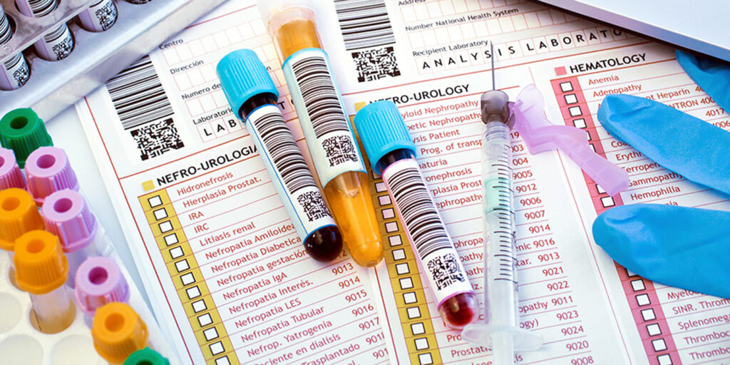 Blood sample vials placed on laboratory test forms for analysis.